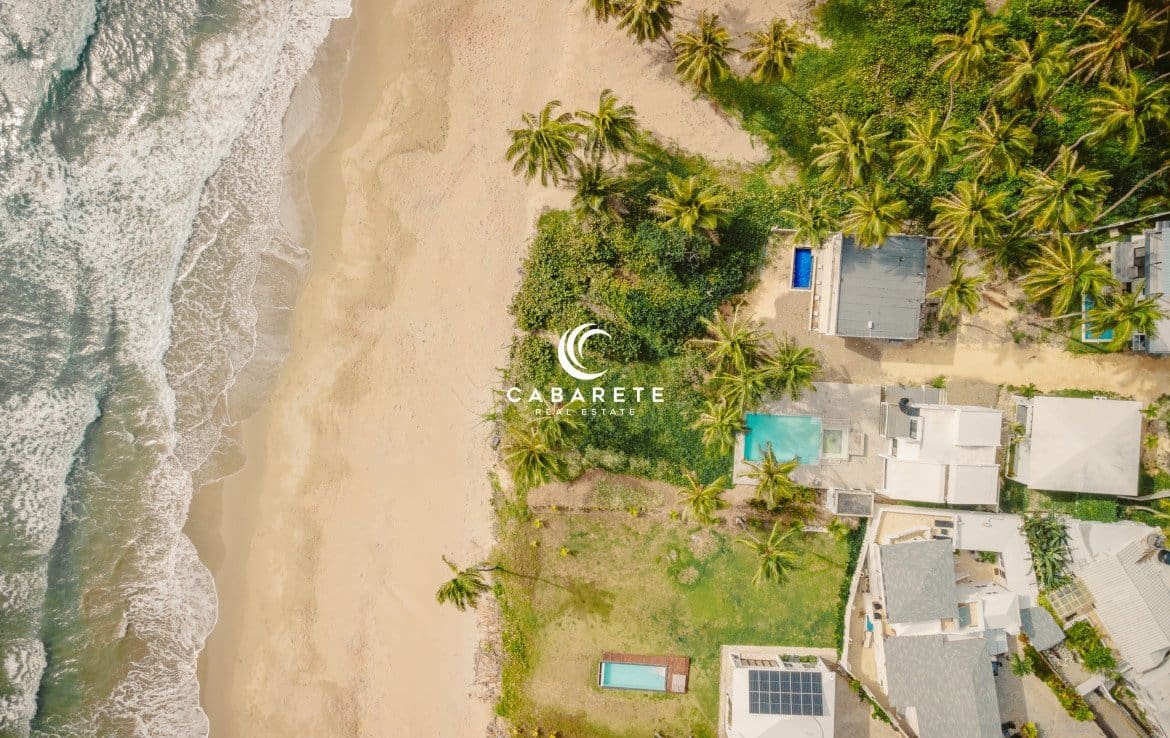 Vue aérienne d'une maison de 4 chambres à coucher en bord de mer à vendre à Cabarete, Puerto Plata, mettant en évidence la plage, l'océan et l'agencement de la propriété.
