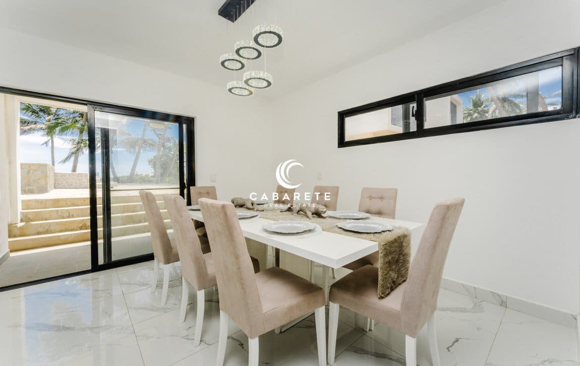 Salon moderne à Cabarete, Puerto Plata, avec des fenêtres allant du sol au plafond et une élégante décoration côtière.