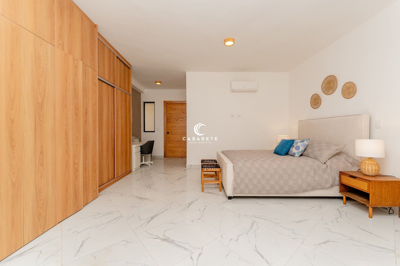 Dormitorio moderno con una cama king-size, un armario y un escritorio.