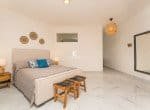 Beautifully decorated bedroom features a king-size bed, a large mirror, and stylish wall decor.