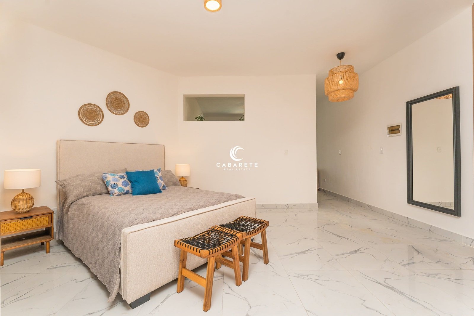 El dormitorio, bellamente decorado, cuenta con una cama king-size, un gran espejo y una elegante decoración en la pared.