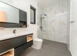 Modern bathroom with a walk-in shower, a vanity, and a toilet.