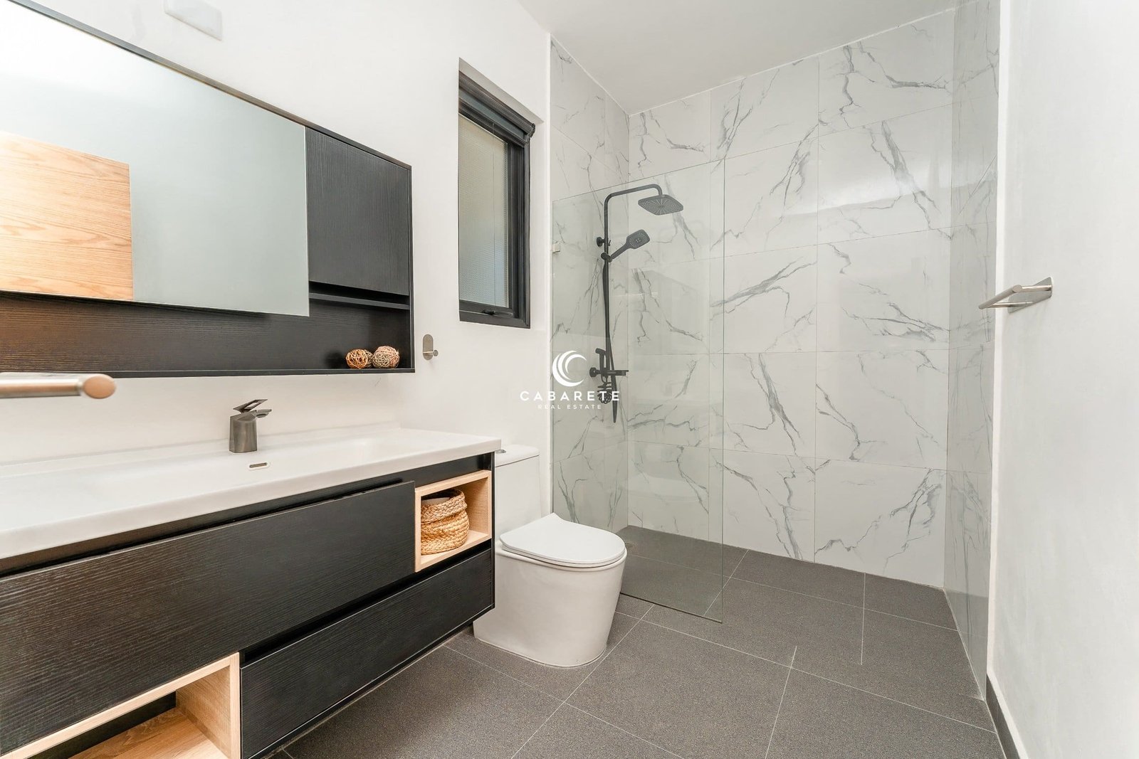 Moderno cuarto de baño con ducha a ras de suelo, tocador e inodoro.