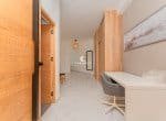 Modern hallway with a desk, a chair, and a closet.