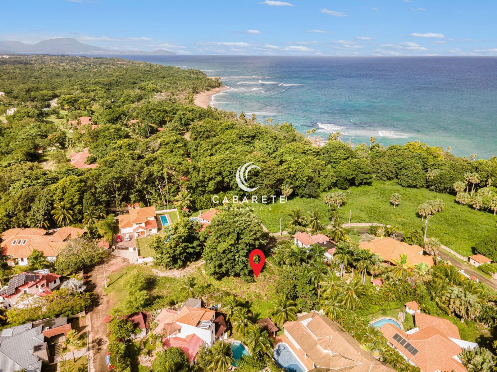 Prime Land for Sale in Perla Marina, Dominican Republic – A tropical lot with lush greenery, ideal for building a luxury home in a gated beachfront community.