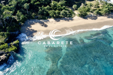 Lush coastal parcel with waves crashing along the sandy shoreline in Playa Laguna