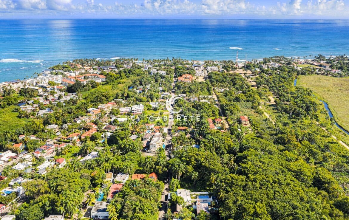 Land for sale in ProCab Cabarete located inside a gated community, featuring a flat buildable lot surrounded by tropical vegetation