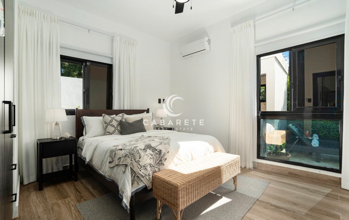 bright modern bedroom with black windows and wooden bed frame