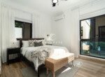 bright modern bedroom with black windows and wooden bed frame