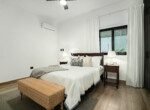 minimalist bedroom white linen bed wooden nightstands wicker bench