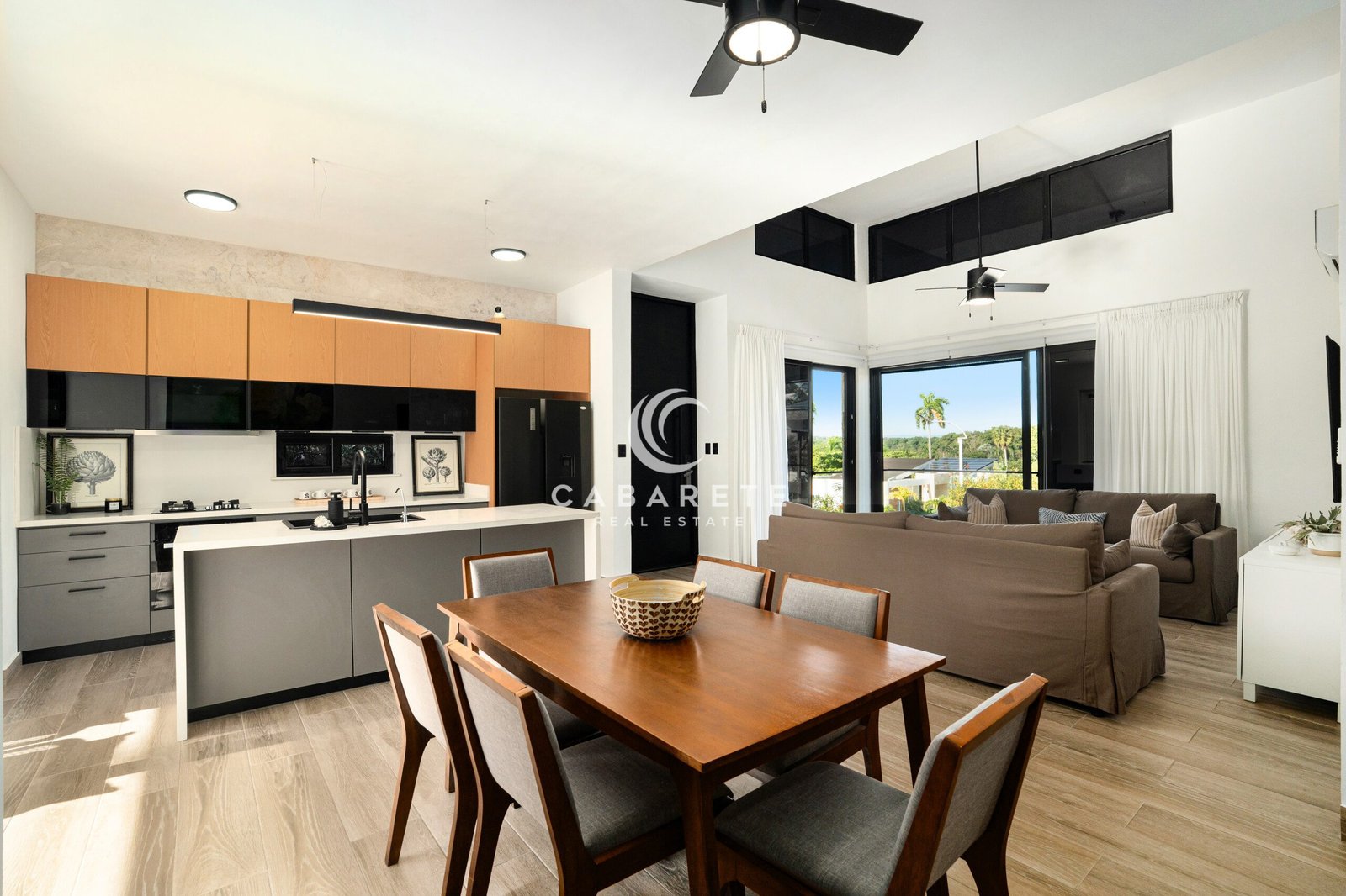open concept kitchen dining living room with island and greenery view