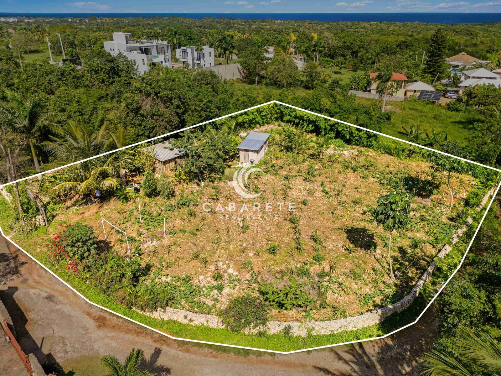 Aerial shot showing irregular land with metal roofs and ocean dream apartment views